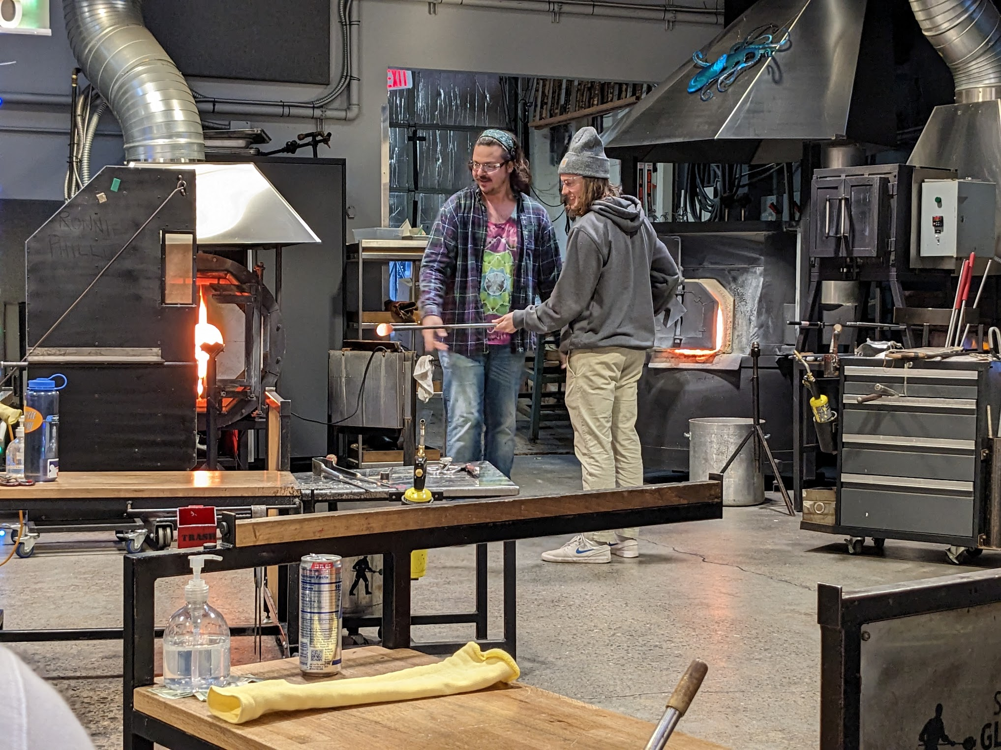 Tyler Weir doing glassblowing with a supervisor